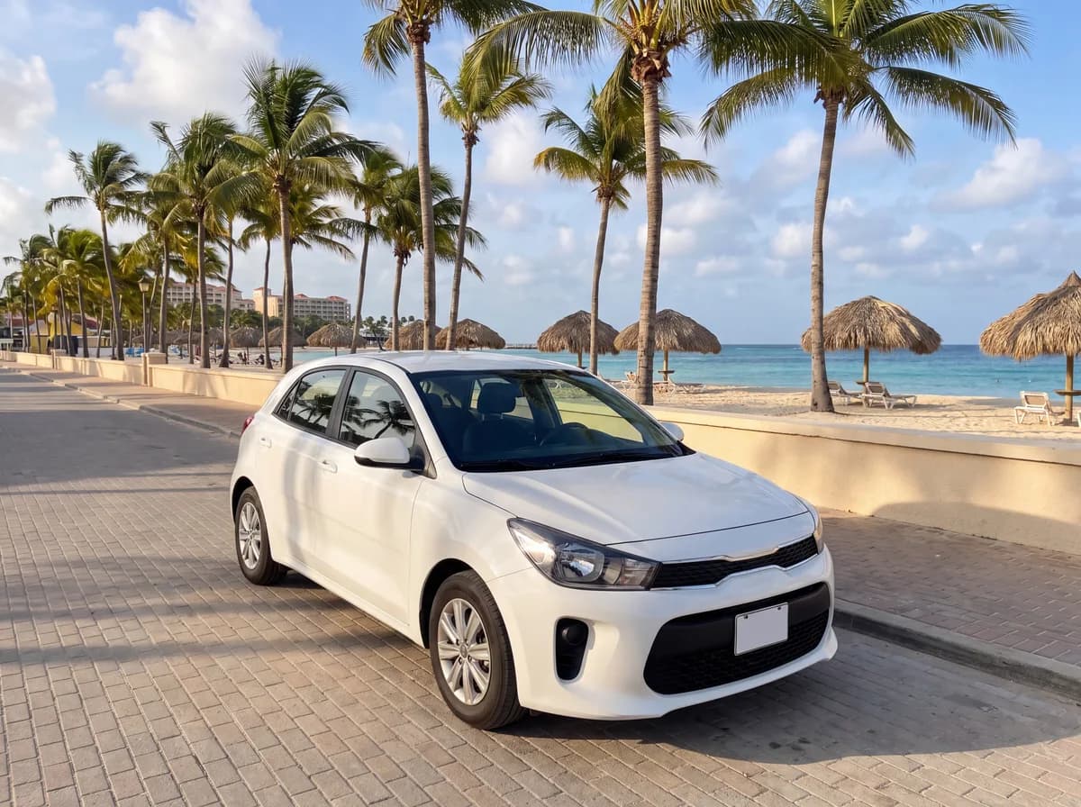 White compact hatchback parked along the palm-lined beach road near Palm Beach, Aruba